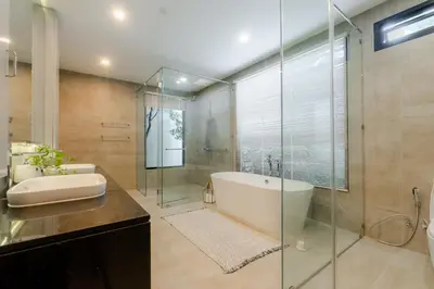 a bathroom with a tub and a glass shower at Fully renovated Pool Villa 4BR Bangtao and Layan Beach in Cheong Thalea, Phuket in Phuket