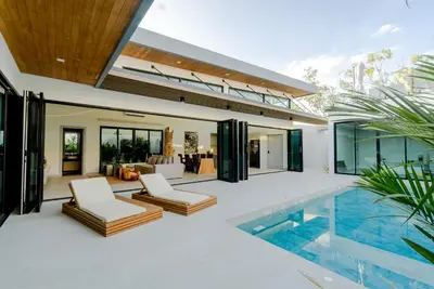an exterior view of a house with a swimming pool at Fully renovated Pool Villa 4BR Bangtao and Layan Beach in Cheong Thalea, Phuket in Phuket