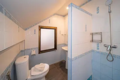 a bathroom with a toilet and a sink and a mirror at Coast Charm 6BR House Karon in Karon Beach