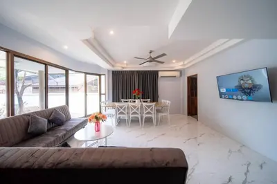 a living room with a couch and a table at Coast Charm 6BR House Karon in Karon Beach