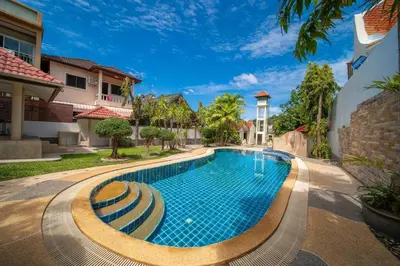 a swimming pool in the middle of a house at Coast Charm 6BR House Karon in Karon Beach