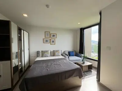 a bedroom with a large bed and a couch at The Base Central Phuket in Phuket Town