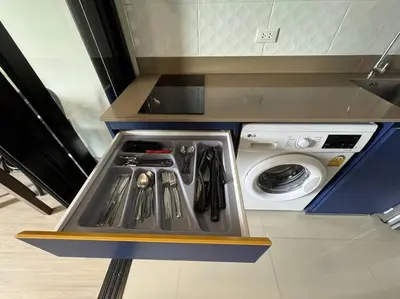 a kitchen with a stove and a washing machine at The Base Central Phuket in Phuket Town