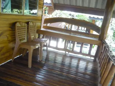 a wooden porch with two chairs and a piano at Pasai Beach Lodge in Ko Yao Noi
