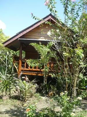 a small cabin in the middle of a garden at Pasai Beach Lodge in Ko Yao Noi