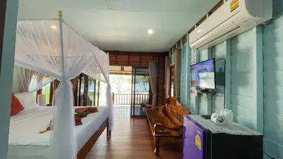 a bedroom with a bed with a canopy at Koh Yao Seaview Bungalow in Ko Yao Noi