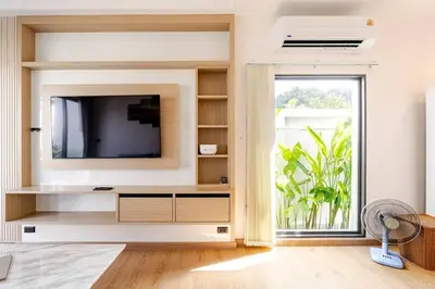 a living room with a tv and a large window at Oasis by the Sea M1- House with Pool and Amenities in Phuket Town