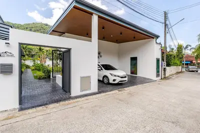 a white house with a car parked outside of it at Oasis by the Sea M2- House with Pool and Amenities in Phuket Town
