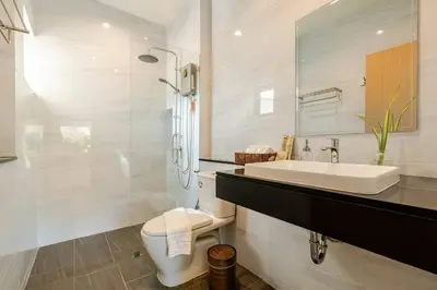 a white bathroom with a sink and a toilet at Oasis by the Sea M3- House with Pool and Amenities in Phuket Town