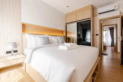 a large white bed with a towel on top of it at Oasis by the Sea M3- House with Pool and Amenities in Phuket Town