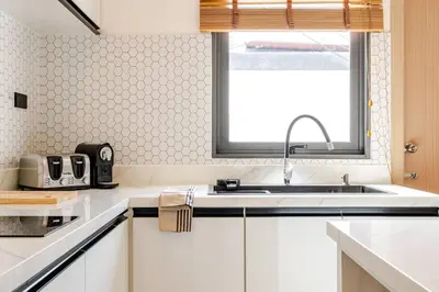 a white kitchen with a sink and a window at Oasis by the Sea M3- House with Pool and Amenities in Phuket Town