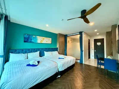 a bedroom with a large bed with a ceiling fan at Deluxe Twin Bed Apartment by Renttini in Kamala Beach