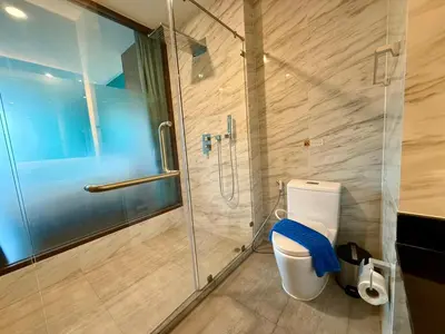 a bathroom with a glass shower and a toilet at Deluxe Twin Bed Apartment by Renttini in Kamala Beach