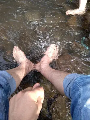 a person holding their feet in the water at Merkezde Havuzlu Lüks Rezidans in Ban Rangeng