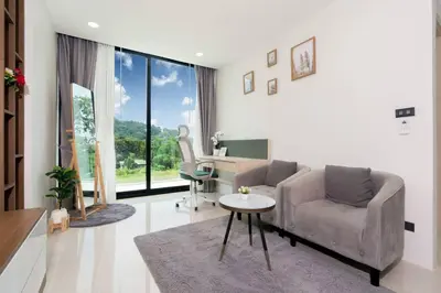a living room with a couch and a desk at Sunset Mountain View 2bedroom Patong in Patong Beach