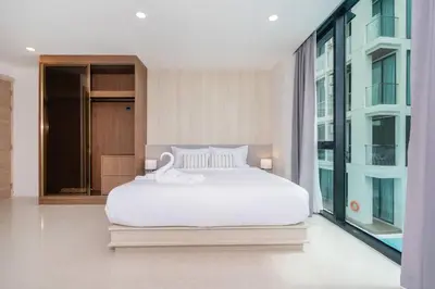a bedroom with a white bed and a large window at Sunset Mountain View 2bedroom Patong in Patong Beach