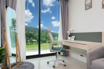 a room with a desk and a chair and a window at Sunset Mountain View 2bedroom Patong in Patong Beach