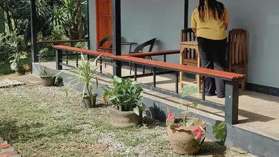 a woman standing next to a wooden bench at Bung Bud Garden Bungalows & Homestay - Koh Yao Noi in Phangnga