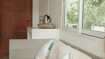 a bed in a room with a window at Bung Bud Garden Bungalows & Homestay - Koh Yao Noi in Phangnga