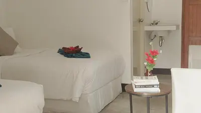 a bedroom with a bed and a table with flowers on it at Bung Bud Garden Bungalows & Homestay - Koh Yao Noi in Phangnga