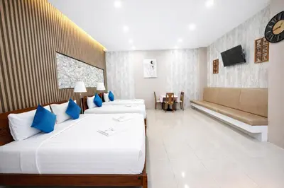 a hotel room with two beds and a couch at KS Residence Patong in Patong Beach
