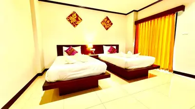 a hotel room with two beds and a window at KS Residence Patong in Patong Beach