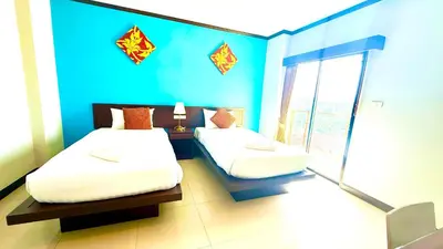 a bedroom with two beds and a blue wall at KS Residence Patong in Patong Beach