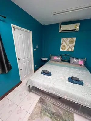 a bedroom with a bed and a blue wall at Ciao Bella GuestHouse & Bistro in Kata Beach