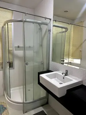 a bathroom with a sink and a glass shower at Сhic condo студия с бассейном in Karon Beach
