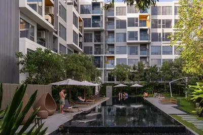 a building with a pool in front of a building at Laguna Lakeside Apartment Phuket Bang Tao in Bang Tao Beach