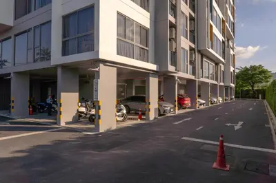 a building with cars parked in a parking lot at Laguna Lakeside Apartment Phuket Bang Tao in Bang Tao Beach