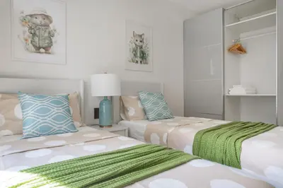 a bedroom with two beds and a couch at Title Halo Wild Spirit Naiyang Pool Gym 2BR in Nai Yang Beach