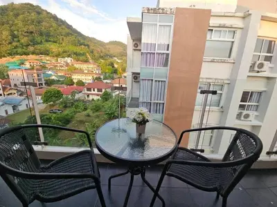 a table and chairs on a balcony with a view at Chic condominium karon beach in Karon Beach