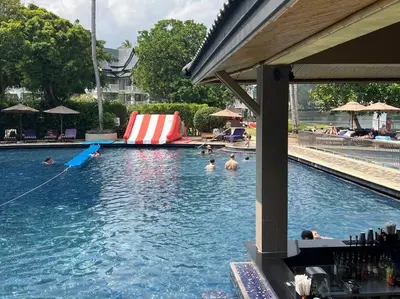a swimming pool with people in the water at Angsana Laguna Phuket, family suite villa duplex, private unit with hotel kids club, pools and beach access in Laguna Phuket