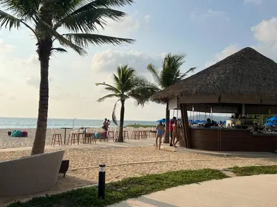 a bar on a beach with palm trees and the ocean at Angsana Laguna Phuket, family suite villa duplex, private unit with hotel kids club, pools and beach access in Laguna Phuket