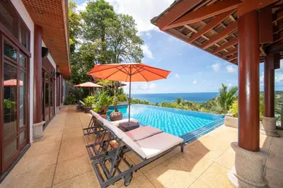 a patio with an umbrella and a swimming pool at surin Luxurious 6br private swimming pool stunning sunset in Phuket Town