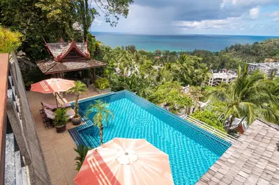 an overhead view of a swimming pool with umbrellas and the ocean at surin Luxurious 6br private swimming pool stunning sunset in Phuket Town