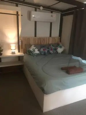 a bed in a room with a lamp on a table at Cancel in Phang-nga