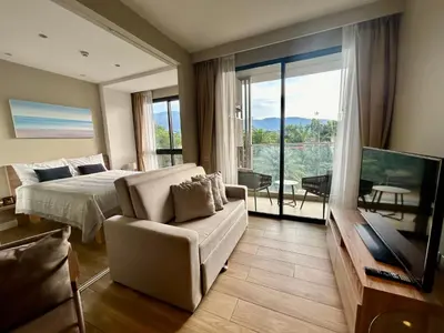 a bedroom with a bed and a couch and a tv at Cozy apartment with a Resort Facilities in Bangtao in Bang Tao Beach