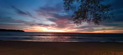 a sunset on a beach with the ocean at Cozy apartment with a Resort Facilities in Bangtao in Bang Tao Beach
