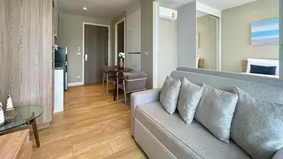 a living room with a couch and a dining room at Cozy apartment with a Resort Facilities in Bangtao in Bang Tao Beach