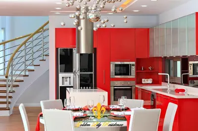 a kitchen with red cabinets and a table with chairs at Golden Lily 4 Bedroom Private Pool Villa in Rawai Beach