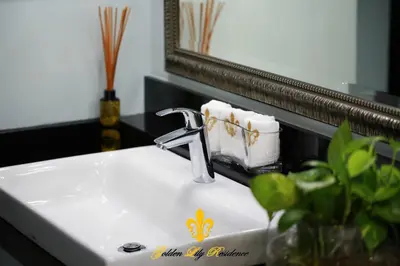 a bathroom sink with a faucet and a mirror at Golden Lily 4 Bedroom Private Pool Villa in Rawai Beach