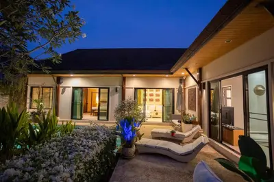 a house with a patio with a couch and flowers at Most Beautiful Relaxation Garden Villa V86 in Rawai Beach