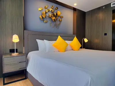 a bedroom with a large white bed with yellow pillows at 2 BDR Suite in 5 Star Hotel in Rawai Beach