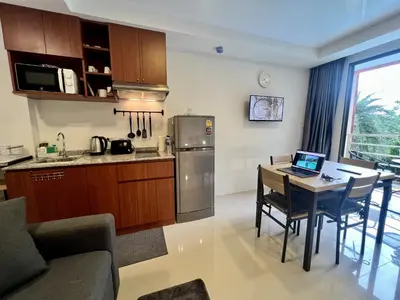 a kitchen and dining room with a laptop on a table at Mai Khao Serenity in Ban Mai Salae