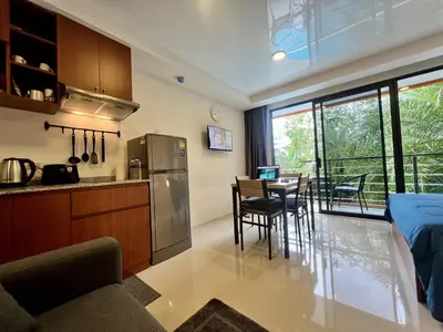 a kitchen and dining room with a table and chairs at Mai Khao Serenity in Ban Mai Salae
