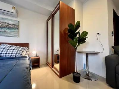 a bedroom with a bed and a table and a mirror at Mai Khao Serenity in Ban Mai Salae