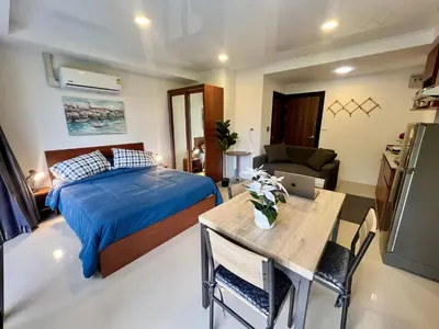 a bedroom with a bed and a table with a laptop at Mai Khao Serenity in Ban Mai Salae