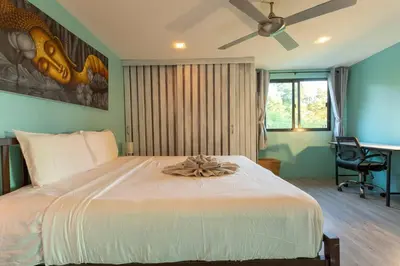a bedroom with a large white bed with a fan at 4 Big Separate Apartments SeaView 8KingBeds v104 in Karon Beach